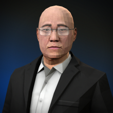 An older balding Chinese man wearing glasses and a suit without a tie.